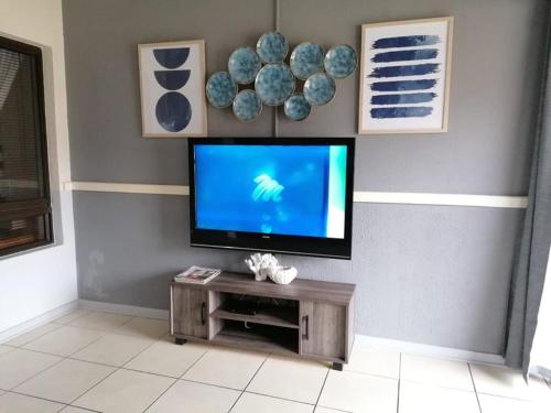 a living room with a flat screen tv on a wall at 78 Cabanas Del Mar in Kingsburgh