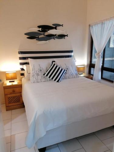 a bedroom with a large white bed with two pillows at 78 Cabanas Del Mar in Kingsborough