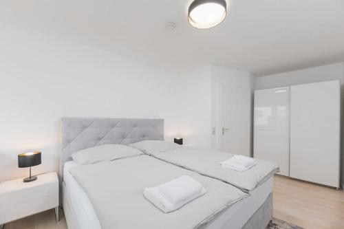 una camera bianca con letto bianco e specchio di S02 Exclusive Stuttgart City 2Room Dream Apartment a Stoccarda
