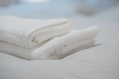 uma pilha de toalhas brancas sobre um fundo branco em S02 Exclusive Stuttgart City 2Room Dream Apartment em Stuttgart