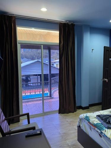 a bedroom with a large window with a view of a building at Mipiace in Kamala Beach