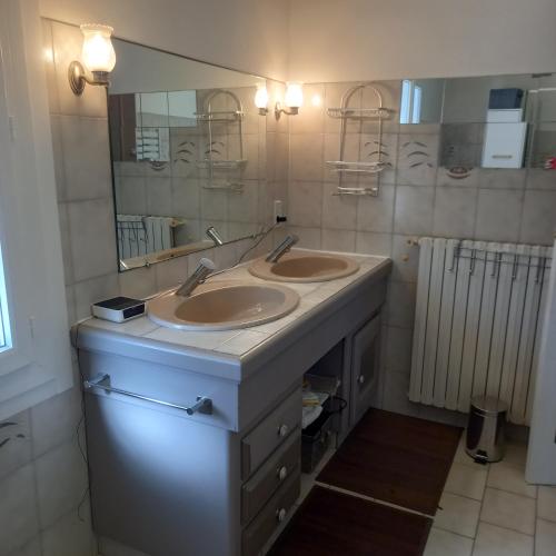 une salle de bain avec deux lavabos et un grand miroir dans l'établissement ADOUR FETES ET PLAISIRS, à Aureilhan