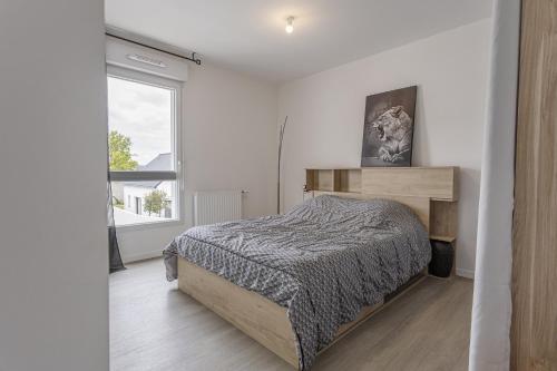 ein Schlafzimmer mit einem Bett und einem großen Fenster in der Unterkunft Le cocon familial in Séné