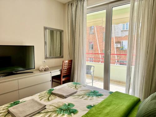 1 dormitorio con 1 cama, TV y ventana en Angel's Luxury heaven Tirana, en Tirana