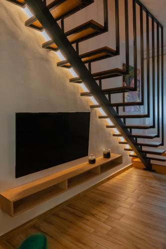 a flat screen tv on a wall under a staircase at Ethra Suite 1 in Volos