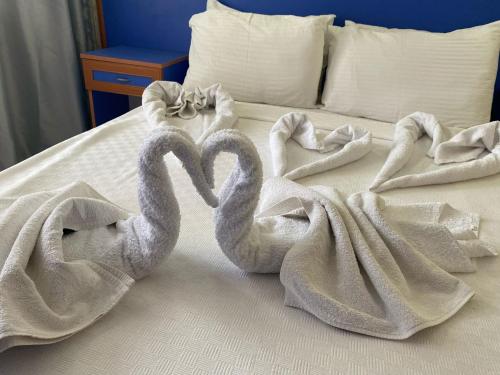 dois cisnes embrulhados em toalhas numa cama em Dilhan Hotel em Marmaris
