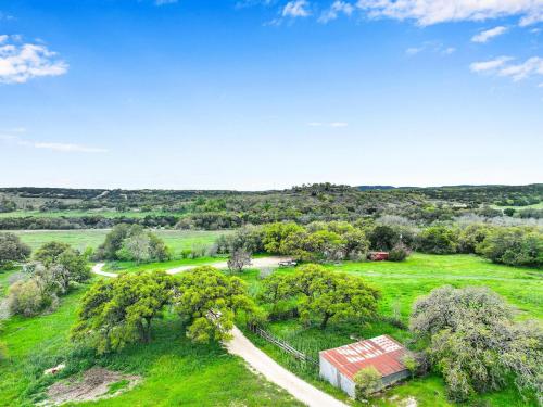 an aerial view of a field with a barn at Lighthouse Hill Ranch - Brown House in Johnson City