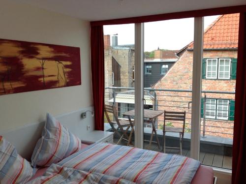 a bedroom with a bed and a view of a balcony at Casa Cinzia Lucia in Eckernförde