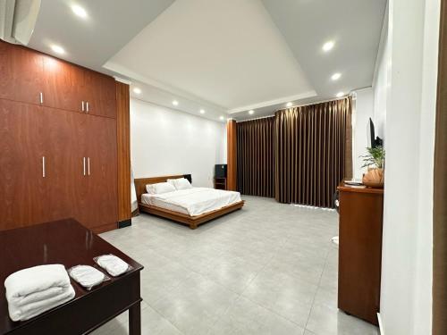 1 dormitorio con 1 cama y armarios de madera en Chi Dep Homestay, en Can Tho