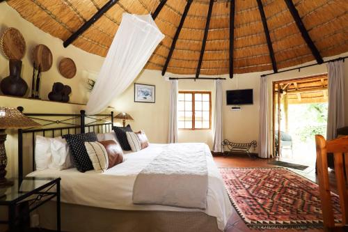 1 dormitorio con 1 cama en una habitación con techo en Kings Grant Country Retreat, en Ixopo