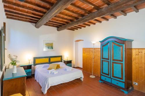 a bedroom with a bed and a blue cabinet at Borgo La Casaccia in Montaione