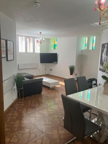 a living room with a table and chairs and a television at Luna Church Conversion 1 in Blackpool