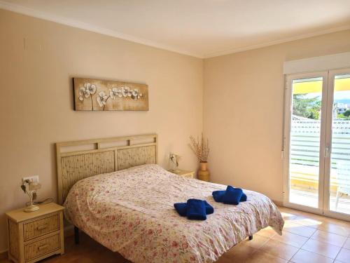 um quarto com uma cama com toalhas azuis em Bungalow Aldea del Mar em Els Poblets