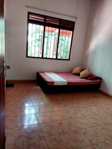 1 dormitorio con 1 cama en una habitación con ventana en Villa in Hikkaduwa, en Dodanduwa