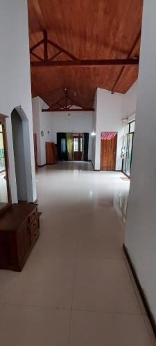 a large room with a large white floor and a wooden ceiling at Villa in Hikkaduwa in Dodanduwa