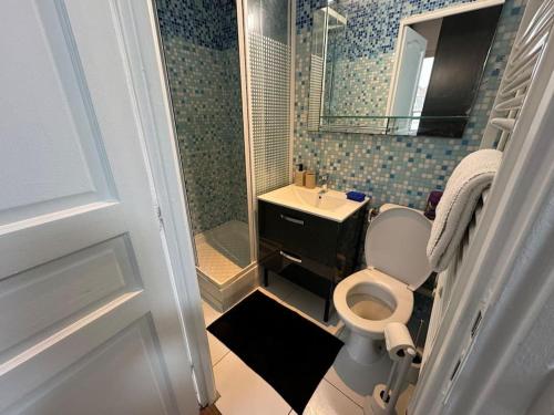 een badkamer met een toilet, een wastafel en een douche bij Logement calme et cosy au Centre-Ville in Saint-Cyr-lʼÉcole