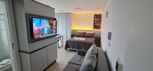 a living room with a couch and a television at Uniquo Residence in Florianópolis