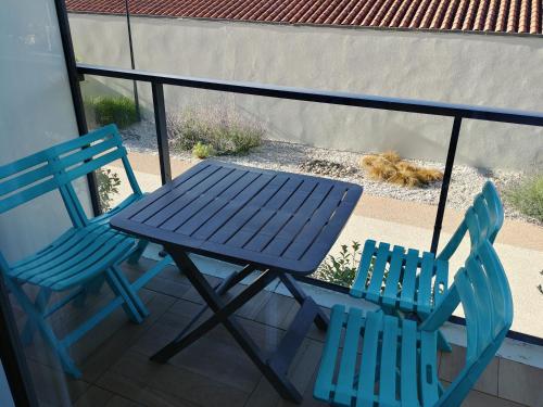 deux chaises bleues et une table de pique-nique sur un balcon dans l'établissement Studio Port des Minimes, à La Rochelle