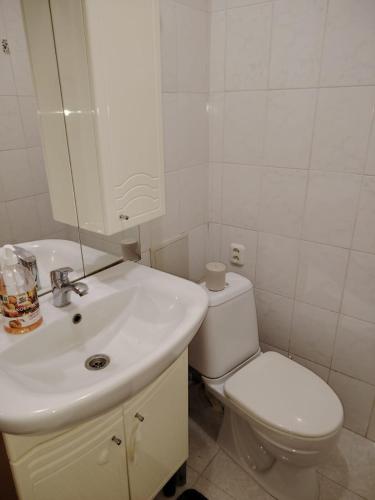 La salle de bains blanche est pourvue de toilettes et d'un lavabo. dans l'établissement 1ком кв центр вокзал, à Uralsk