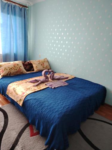 - une chambre avec un lit doté d'un couvre-lit bleu dans l'établissement 1ком кв центр вокзал, à Uralsk