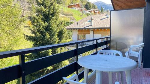 a table and chairs on the balcony of a house at Ramuge COSY & MOUNTAINS apartments in Veysonnaz