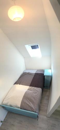 un lit dans une petite pièce avec un plafond dans l'établissement Cottage de la Mer, au Crotoy