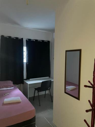 a room with a bed and a desk and a mirror at Pousada Aeroporto Viracopos Campinas in Viracopos