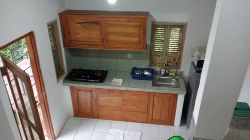 a small kitchen with wooden cabinets and a sink at Liri Villa - 4 BRs - Ocean, Valley view in Temukus