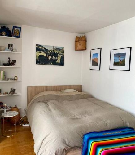 une chambre avec un grand lit dans une pièce dans l'établissement Charmant studio lumineux en plein centre de Paris, à Paris