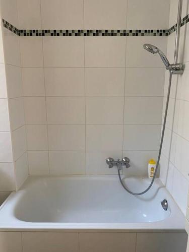 La salle de bains est pourvue d'une baignoire et d'une douche. dans l'établissement Charmant studio lumineux en plein centre de Paris, à Paris