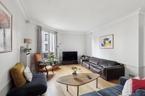 un salon avec un canapé et une table dans l'établissement Grand appart 140m² à deux pas de la Tour Eiffel, à Paris