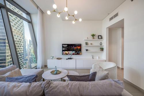 a living room with a couch and a tv at Burj Khalifa & Fountain Views, Exclusive Apartment in Burj Vista Building in Dubai