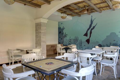 una sala da pranzo con tavoli, sedie e un murale di Pool view 2BHK 5 min to Airport a Vasco da Gama
