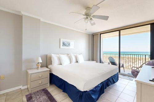 een slaapkamer met een bed en een balkon met uitzicht op de oceaan bij Emerald Surf 102 in Navarre