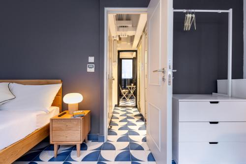 a bedroom with a bed and a blue and white floor at Habyt Bridges - 66 Staunton Street in Hong Kong