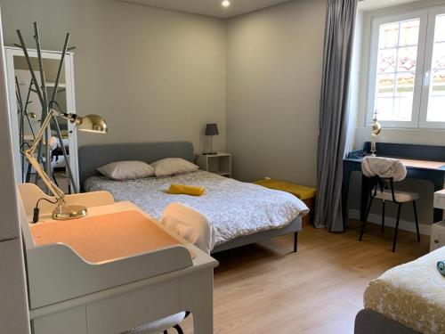 a bedroom with a bed and a desk and a desk at Quebra Costas House in Coimbra