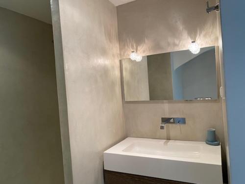 une salle de bain avec un lavabo blanc et un miroir dans l'établissement Villa Prestige Porto Vecchio, à Furoli