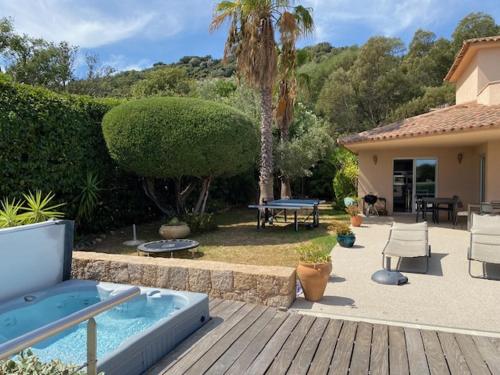 une cour arrière avec une piscine, une table et des chaises dans l'établissement Villa Prestige Porto Vecchio, à Furoli
