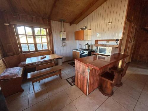 a small kitchen with a table and a stove at •Cabañas Patagonia• in Puerto Montt