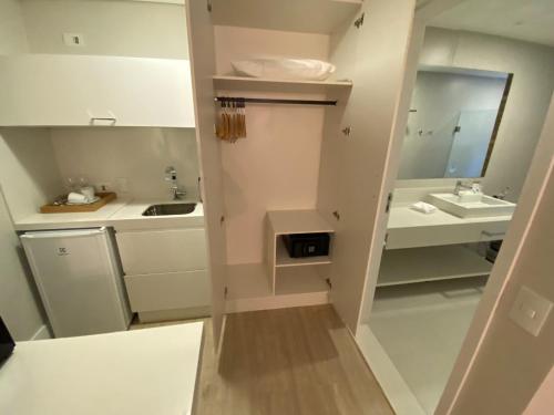ein kleines weißes Bad mit einem Waschbecken und einem Spiegel in der Unterkunft Carpe Diem Boutique & Spa in Campos do Jordão