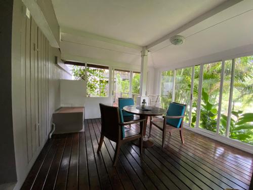 a dining room with a table and chairs on a balcony at Stephna Residence in Anse Boileau