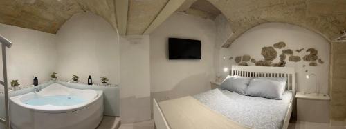 a bathroom with a tub and a bed and a sink at Casa dei Martiri in Altamura