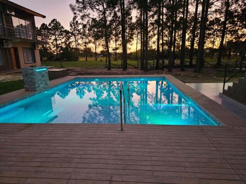 a swimming pool with blue water in front of a house at Villa Termal Norte in Federación
