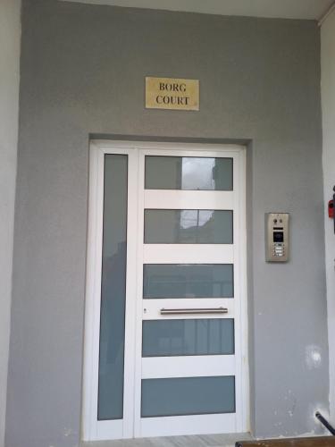 a door in a building with a house court sign above it at Yellow Hill Penthouse in Żebbuġ