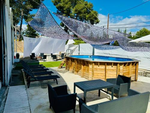 a patio with tables and chairs and a swimming pool at Bungalow avec piscine in Antibes