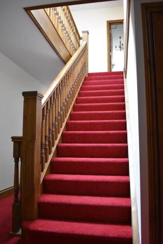 a stairway with red carpet and red stairs at Great Trethew Hotel - Self Catering Lodges - Bar & Restaurant in Liskeard