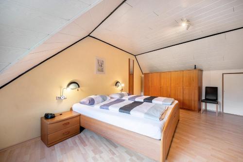 a bedroom with a large bed in a attic at Gästehaus Mühlenhof - Müller-Thurgau in Maring-Noviand