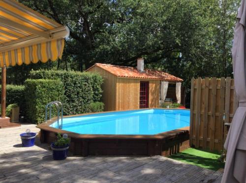 uma piscina num quintal com uma casa de cão em Gîte les Iris Nalliers em Nalliers