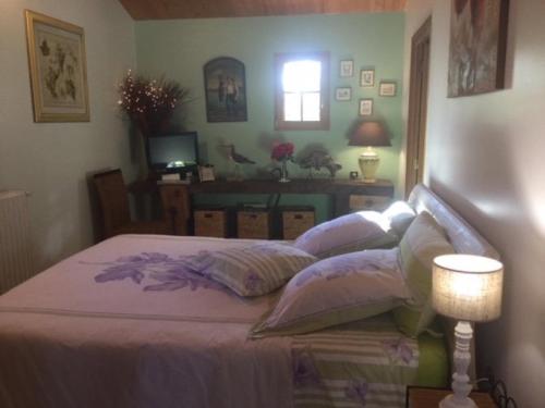 um quarto com uma cama com lençóis e almofadas roxos em Gîte les Iris Nalliers em Nalliers