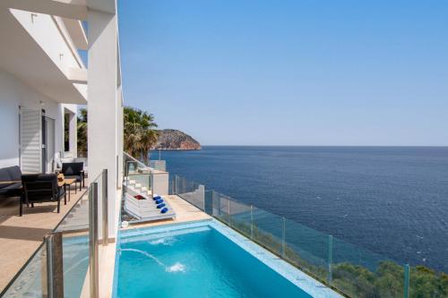 uma vista para o oceano a partir de uma casa com piscina em Villa Can Biel Canyamel by Slow Villas em Canyamel